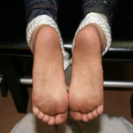 Caucasian woman shows the bottoms of her unkempt feet.