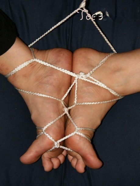 A white woman has her feet tied together with cords.