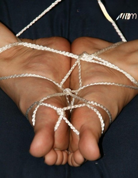 A white woman has her feet tied together with cords.