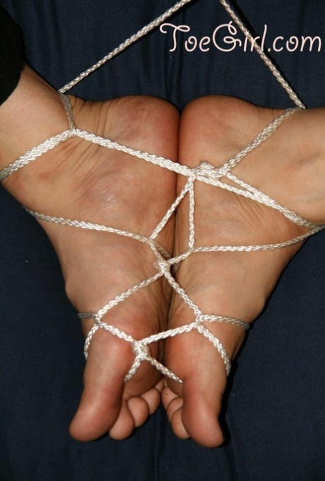 Caucasian women's feet are tightly tied together with cord.