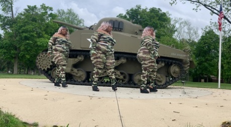 A black woman named Carmelotto Rush, who is obese and black, displays her thong-clad buttocks on the opposite side of a tank.