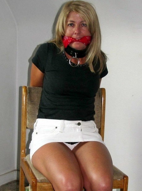 Her ankles and wrists are tied with rope while a blonde woman is gagged.