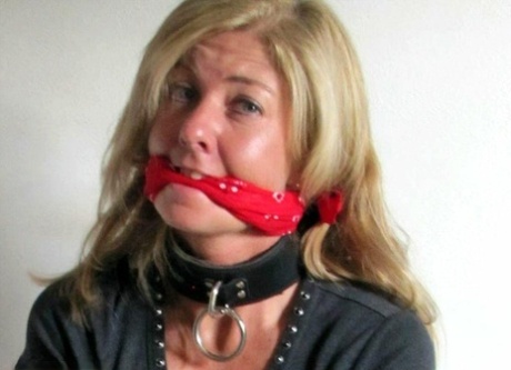 A blonde woman is draped with rope, her ankles and wrists tied off.