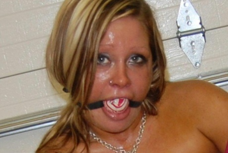Wearing pink pantyhose and heels, the dirty blonde performs a ball gag.
