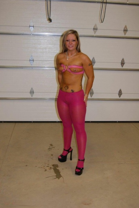 A dirty blonde wears pink pantyhose and heels as she performs a ball gag.