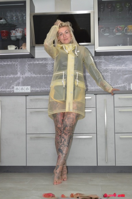 Tattooed Blonde Miss Francine Models Barefoot In A Raincoat Over Rubber Wear