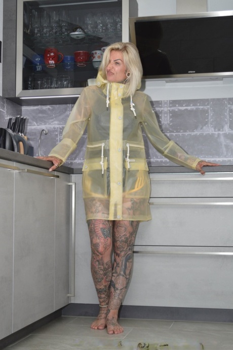 Tattooed Blonde Miss Francine Models Barefoot In A Raincoat Over Rubber Wear