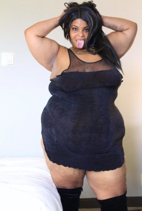 Ebony SSBBW Carmel Squirtz pulls off her large buttocks in a black dress.