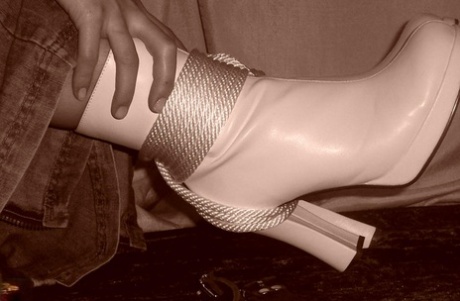 The sole model is tied up with rope and fully dressed in white boots.