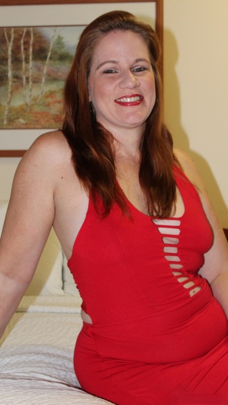 A redheaded plumper named Ginger Reigh shows off her painted toenails in a red dress.