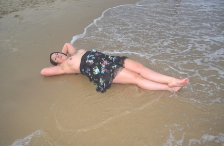 A solo female amateur flaunts her clothes while changing her attire at the beach.