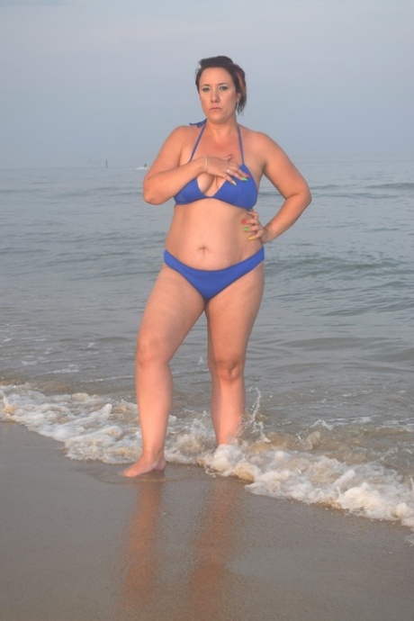 At the beach, a solo female amateur changes her attire while changing into a pool.