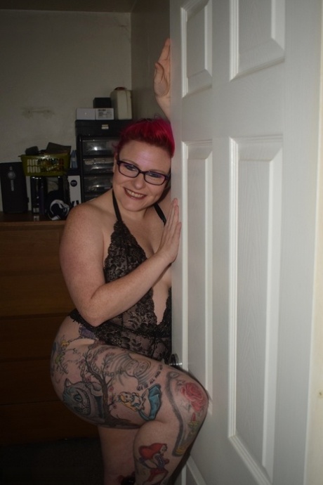 While wearing her glasses on, Mollie Foxxx (an incredibly tattooed redhead) is seen in photos modeling black lingerie.
