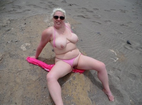 Barby, a platinum blonde with an older physique, flaunts her plump figure at the beach.