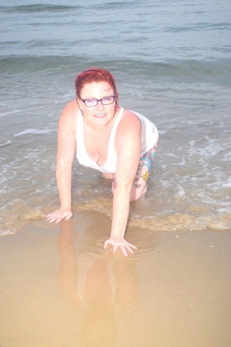 The tattooed redhead floats into the ocean before exposing herself.