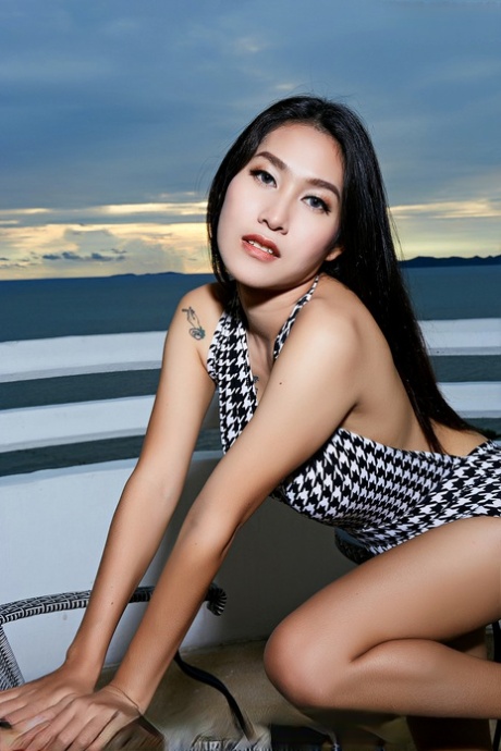 An attractive Asian woman named Linlin exposes herself completely naked on a beachfront balcony.