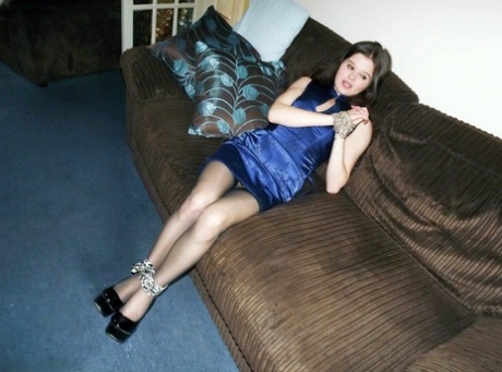 With her arms and ankles tied up, Tamara the clothed girl is on a couch.