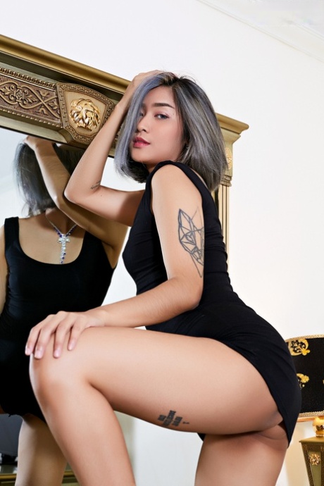 This is an Asian babe with tattoos who looses her small tits and pussy while wearing a little black dress.