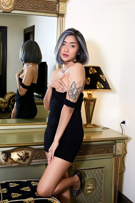 A little black dress accompanies an Asian female tattooed with her tiny tits and pussy loosening.