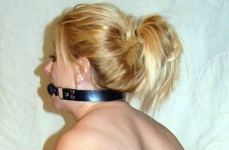 An amateur models carries the ball gag while wearing an adjustable stocking without a backrest.