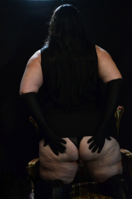 The dark-haired, mature BBW British Foxx seizes her ample buttocks in upset action.