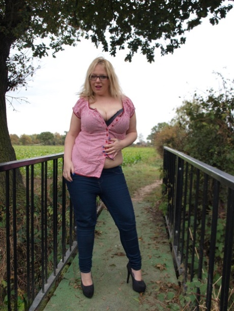 Любительница-толстушка Синди Баст показывает свои большие сиськи и пизду на деревенском мосту