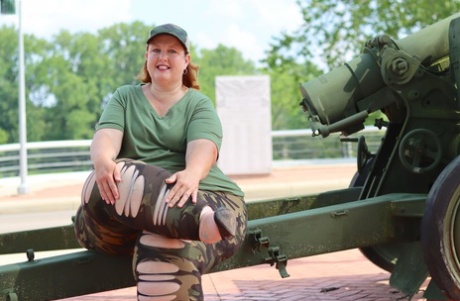 Obese models of the Goddess Pear are dressed in camo and use an artillery gun for a SFW shoot.