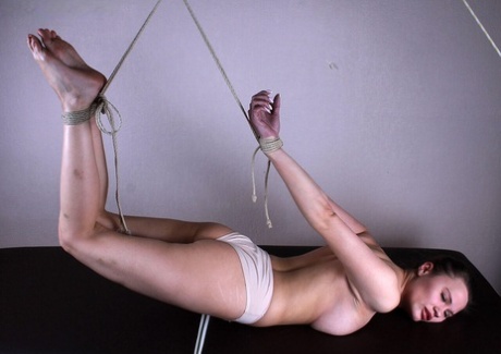 White girl Peggy is suspended in the air by ropes while in white underwear