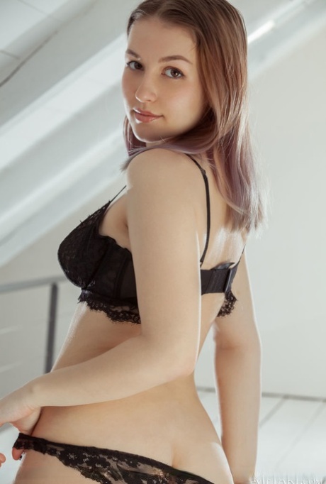Sweet teen Isabele removes her underthings to pose nude in an attic loft