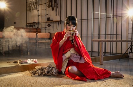 With a rope, Sakura Kurokawa (a Japanese female) is suspended from the ceiling.