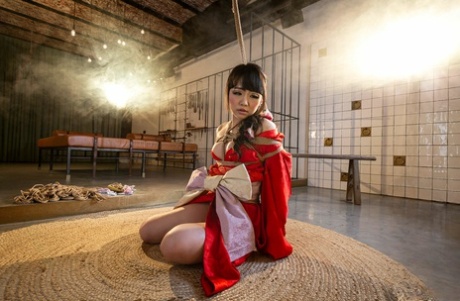 Sakura Kurokawa, a Japanese female, is hanging from the ceiling with a rope.