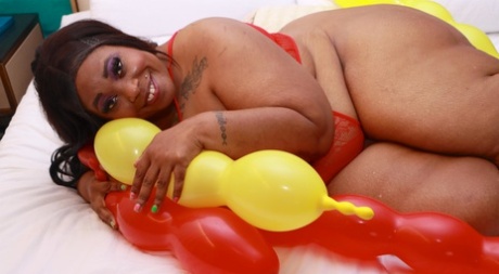 Obese Black Woman Simone Thyke Snuggles Up To Balloons On A Bed In Lingerie