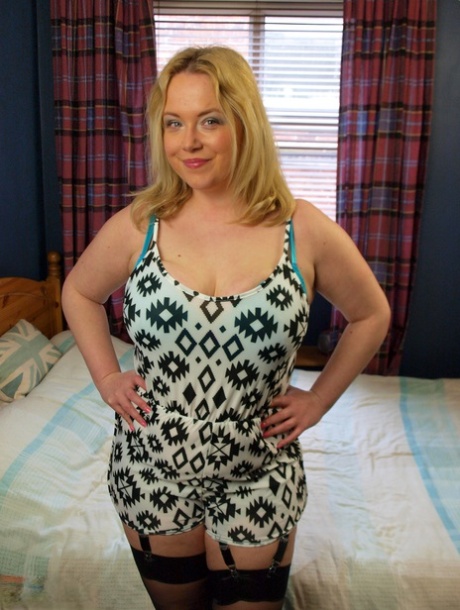 Using her garter and nylons, Sindy Bust exposes her big breasts as a chubby blonde.