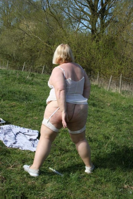 In a field, Lexie Cummings, a fat UK amateur, displays her large buttocks and visible vagina.