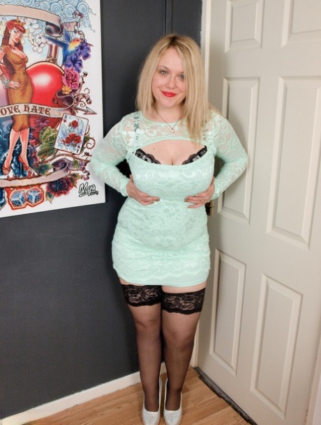 Chubby blonde Sindy Bust strips down to her stockings and heels by herself