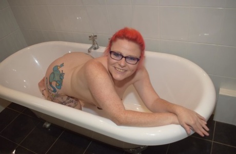 Mollie Foxxx, a 22-year-old redhead, exhibits her tattooed body in the bathroom.