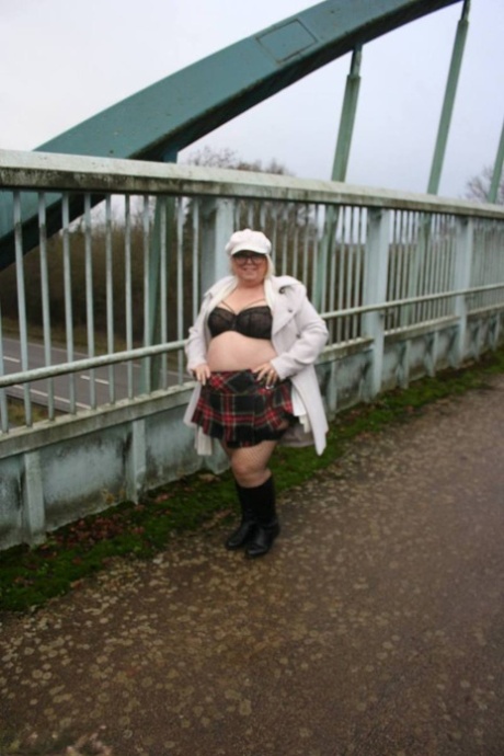 On a pedestrian bridge, Lexie Cummings flaunts her large buttocks while in the UK.