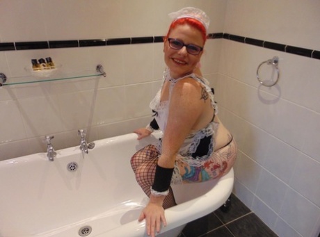 Older reddish cat Mollie Foxxx reveals her natural tits in a bath.