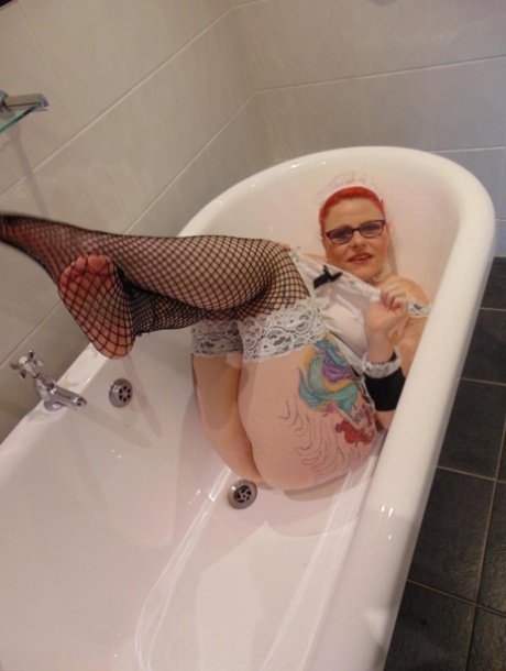 Despite being an older redhead, Mollie Foxxx still exhibits her natural tits while bathing in the tub.