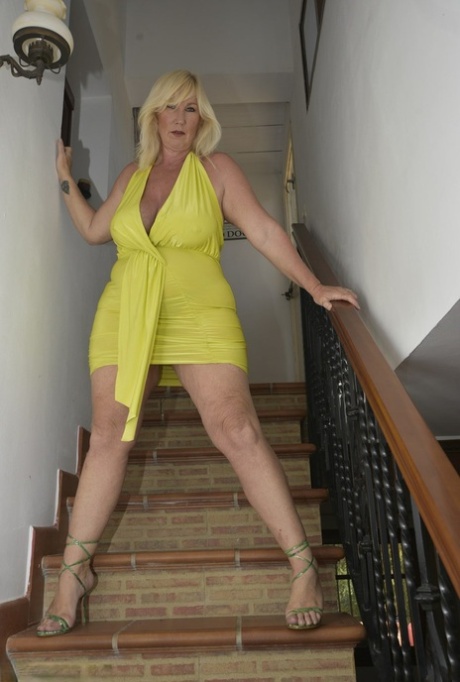 The older blonde, with a thick build, Melody fingers her vagina on a set of stairs.