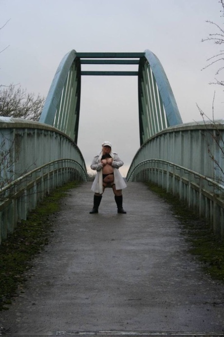 On a pedestrian bridge, Lexie Cummings, an obese Briton, exposes herself.