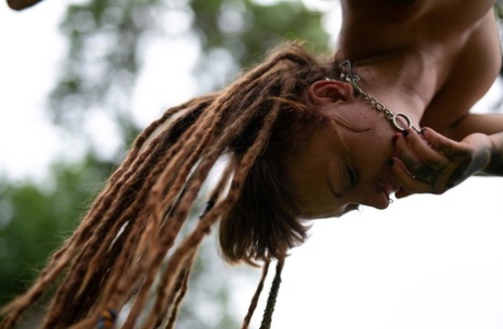 In a yard, Andreaz and Burbz Z, a tattooed couple, are hanging upside down.