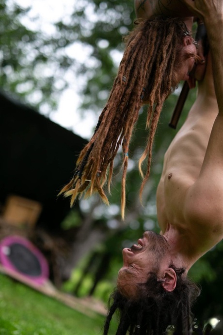 Andreaz & Burbz Z, a tattooed couple, are seen hanging upside down in a yard display.