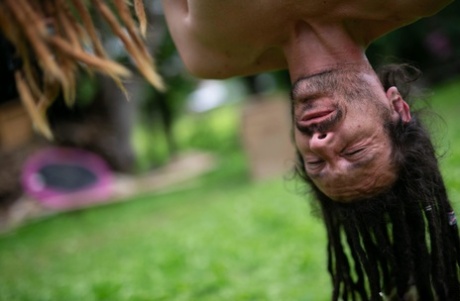 A tattooed pair named Andreaz and Burbz Z are hanging upside down in a yard display.