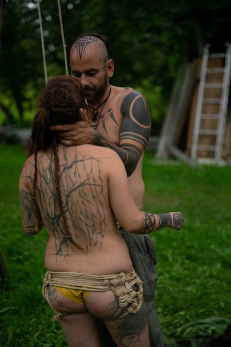 Andreaz & Burbz Z, a tattooed couple, are seen hanging upside down in a yard display.