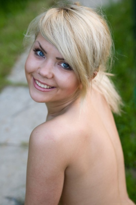 Young and blonde Iveta poses in the nude at a garden party.