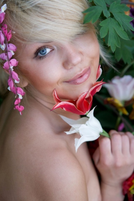 In a garden, Iveta, a charming young blonde, poses in the nude.