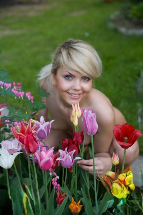 In a garden, Iveta, a charming young blonde, poses in the nude.