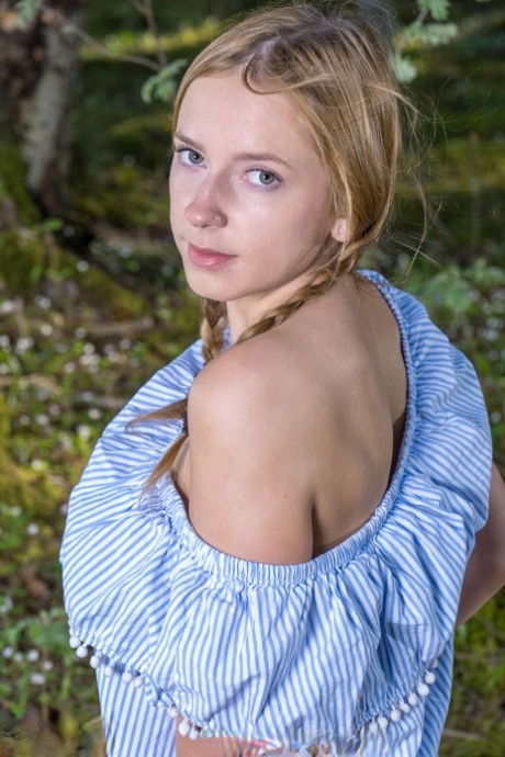 In a forest, Sara the young woman exposes her full breasts and releases her pussy.