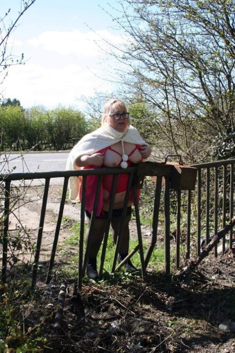 Exposed to the public, Lexie Cummings, an Obésic blonde from the UK, displays her tits and large buttocks in a field.